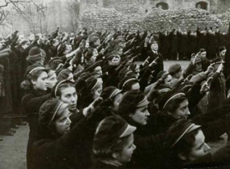 Девушки из Союза стрелков Литвы приветствуют литовский флаг на башне Гедиминаса в Вильнюсе.